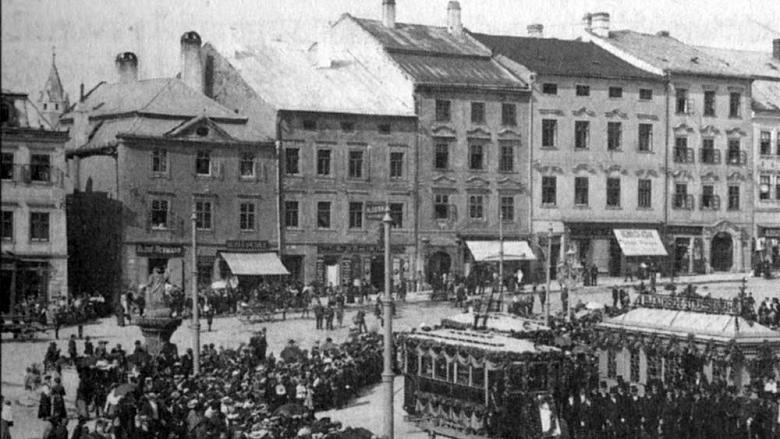 NÁROŽNÍ dům (dnes Masarykovo náměstí 39, druhý zleva) má na fotografii ze slavnostního zahájení provozu elektrické dráhy v Jihlavě 26. srpna 1909 ještě zazděné podloubí v průčelí.  Foto: kniha Jihlava (Historie/kultura/lidé),  Dějiny moravských měst, Li