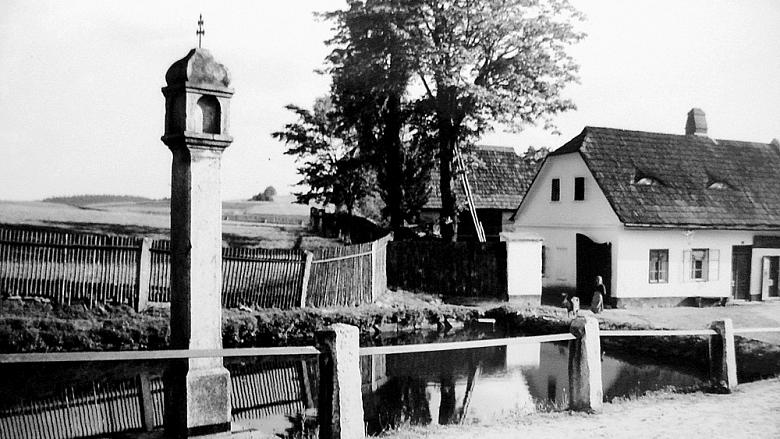 SNÍMEK božích muk ve Vyskytné nad Jihlavou, které se dříve říkalo Německá Vyskytná. V pozadí dům číslo popisné 28.  Zdroj: archiv VN