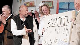 MOMENT z emotivního závěru benefice rantířovských ochotníků v DKO Jihlava. Symbolický šek od divadelníků přebírá Hana Fexová, ředitelka Oblastní charity Jihlava.  Foto: archiv Petra Palovčíka 