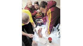 SLOVA trenéra Viktora Ujčíka o odhodlání jeho svěřenců překonat v play off zdravotní problémy potvrzuje snímek z šestého finále Maxa ligy. Doktor a zdravotnický štáb pracují na pochroumaném kotníku útočníka Radka Pořízka. Foto: Michal Boček 
