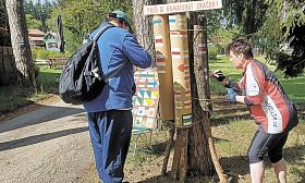 ÚČASTNÍCI tesláckého šotka malují turistické značky na kontrolním stanovišti na Okrouhlíku. Foto: archiv organizátorů pochodu 