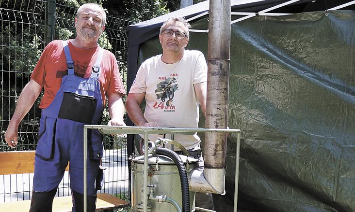 TECHNICKÝ UNIKÁT obsluhovaný Petrem Půlpánem (vlevo) a Martinem Němečkem každoročně osvěžuje účastníky jihlavského závodu horských kol. Podobné typy armádních mobilních koupelen jsou k vidění v dobových válečných dokumentech. Foto: Michal Boček