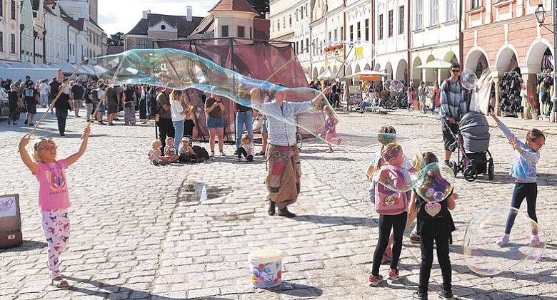 ZAPLNĚNÉ náměstí v Telči patří během letního festivalu také dětem. Užívají si kolotoč, hry či vyfoukávání velkých bublin. Foto: Jiří Varhaník