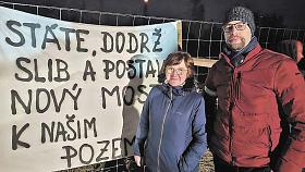 STAROSTKA Kamenice Hana Krejčová u jednoho z transparentů požadující výstavbu nového mostu přes D1 k polnostem na druhé straně dálnice v katastru Řehořova. Na snímku společně s ní předseda řehořovského osadního výboru Jan Rathouský, který v minulosti inic